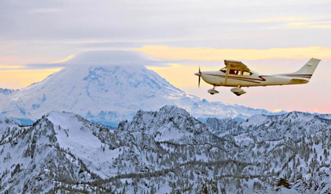 Flugzeug vor schneebedecktem Berg
